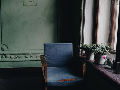 An empty yoga mat on a wooden floor in a sunlit room.